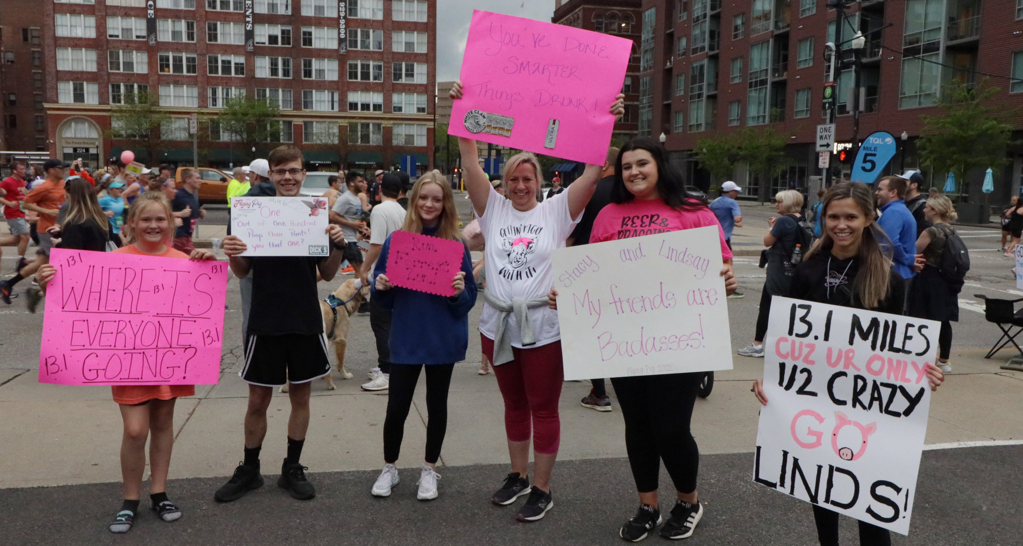 a group of people holding motivational signs along the race course
